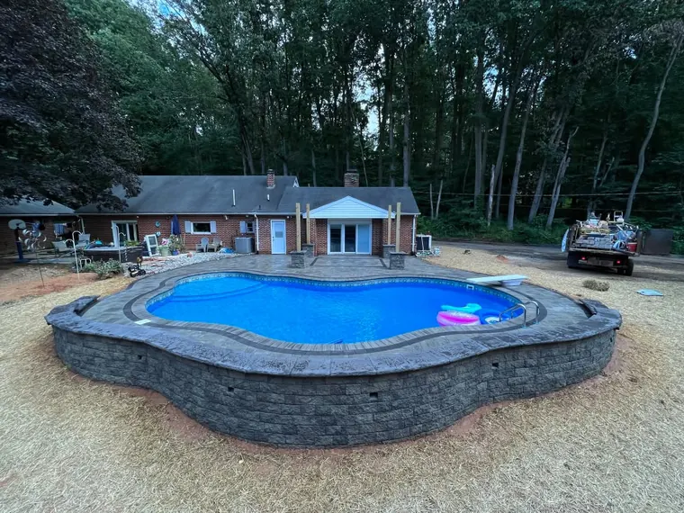 Raised freeform pool wrapped in stone wall